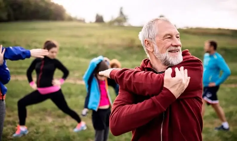 Person doing yoga outdoors, looking peaceful and healthy